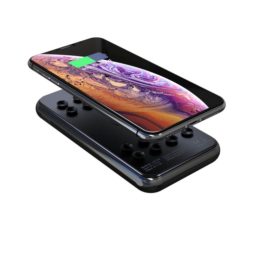 Glass screen wireless power bank aligned in charging position with a mobile phone.