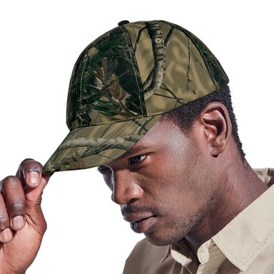 A man wearing a hardy camo cap. He is holding the tip of the peak