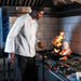 Chef cooking in a kitchen wearing a white chef jacket from Custom Brands Promotions